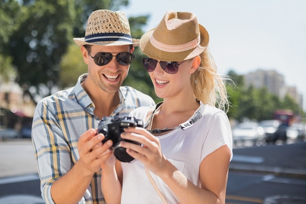 Hanche jeune couple en regardant leur caméra