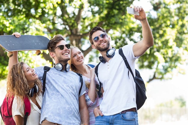 Hanches amis prenant selfie à l&#39;extérieur