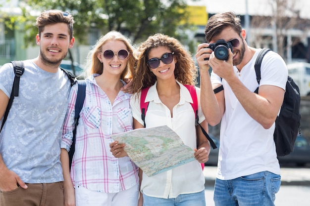 Hanches amis tenant une carte et prenant des photos à la caméra dans la ville