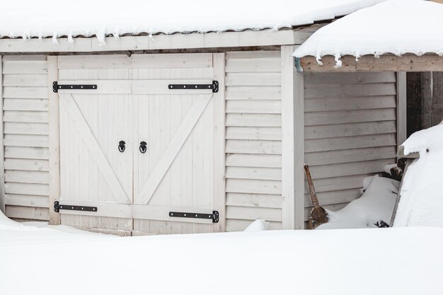 Hangar en bois couvert de neige après de fortes chutes de neige