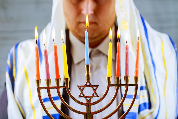 Hanukkah une célébration juive Bougies allumées dans la menorah homme en arrière-plan