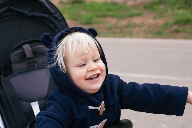 Happy Baby boy sitting poussette sur la nature en plein air