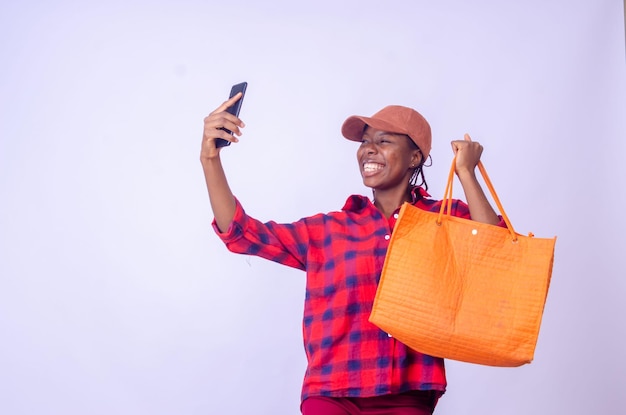 Happy Black Lady utilisant une application mobile sur un smartphone pour faire des achats en ligne