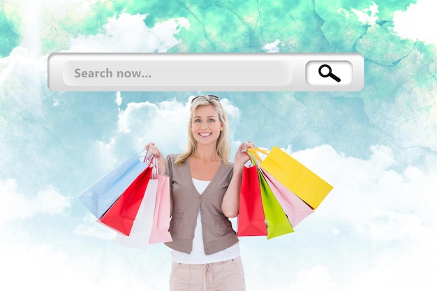 Photo happy blonde holding shopping bags contre ciel vert et bleu