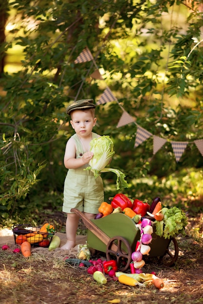 Happy boy prépare une salade de légumes dans la nature