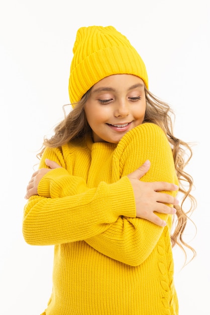 Happy caucasian girl in yellow hat et hoody sourit et se réjouit isolé sur fond blanc