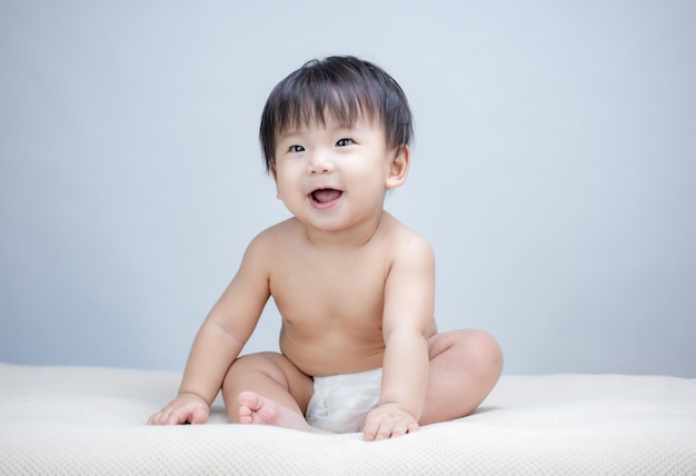 Happy Child Baby Toddler Sitting In Diaper on bed