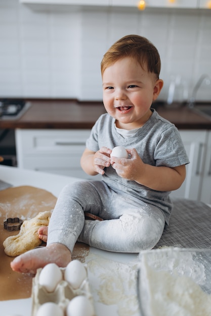 Happy family funny boy prépare la pâte, cuire des cookies dans la cuisine