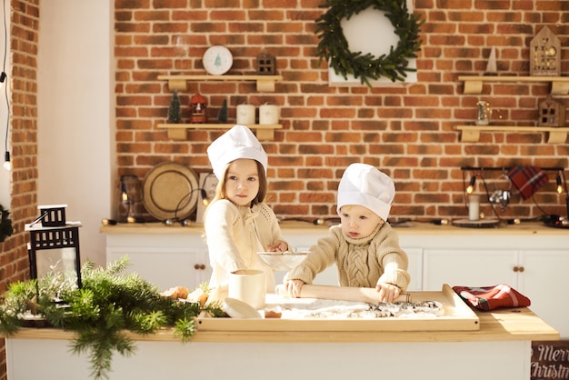 Happy family funny kids prépare la pâte, joue avec de la farine dans la cuisine