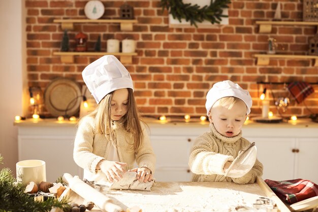 Happy family funny kids prépare la pâte, joue avec de la farine dans la cuisine