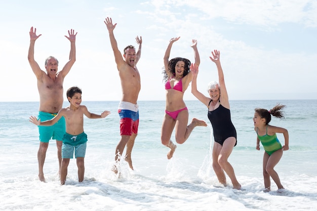 Happy family multi génération sautant à la plage