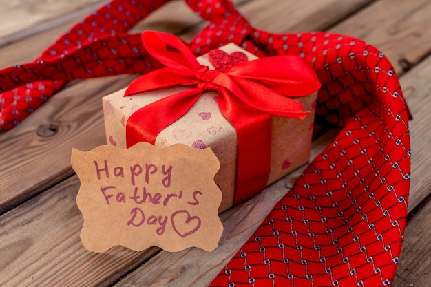 Happy Fathers Day gift craft box avec cravate rouge sur fond de bois rustique. Carte de voeux