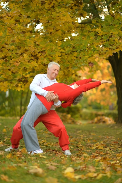 Happy fit senior couple exerçant dans le parc d'automne