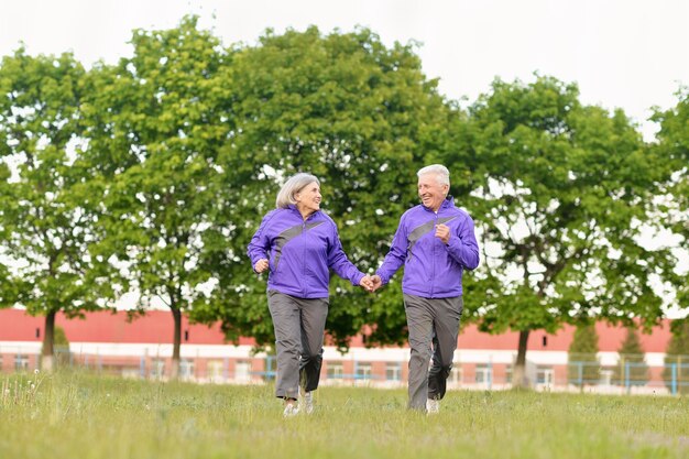 Happy fit senior couple jogging dans le parc