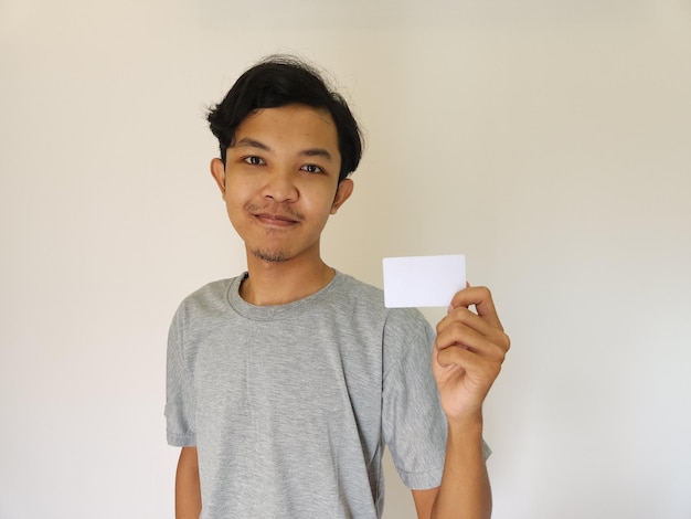 Happy funny face Asian man montrer sa carte vide sur fond blanc