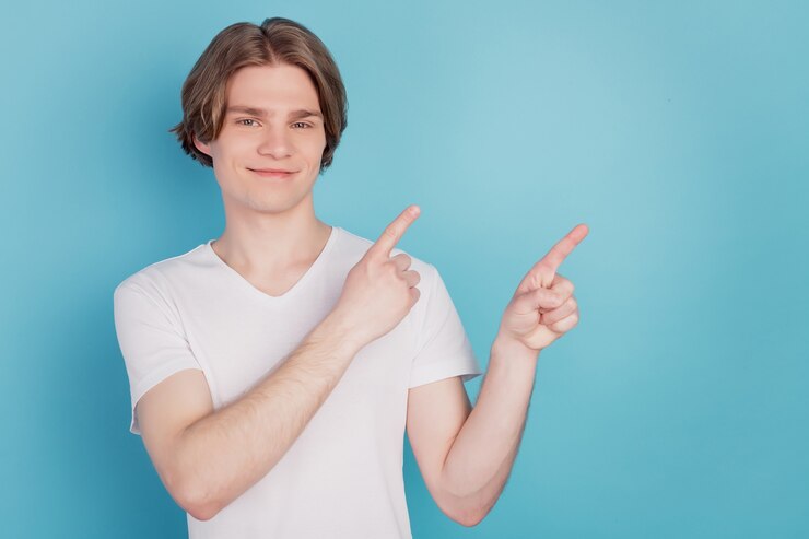 Happy guy isolé sélectionnez annonces montrant pointant avec le fond de l'espace vide bleu doigt