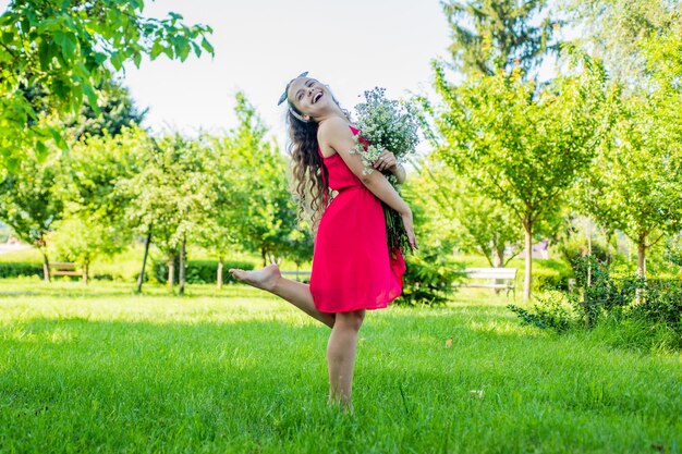 Happy kid girl récoltant des fleurs de camomille bio