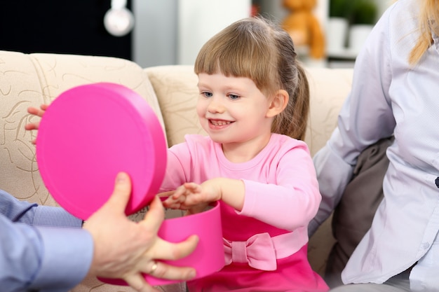 Happy little girl open present box de ses parents