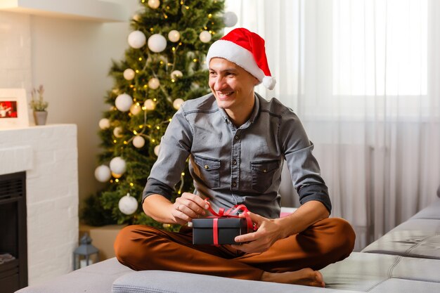 Happy Mid adult man près de l'arbre de Noël à la maison