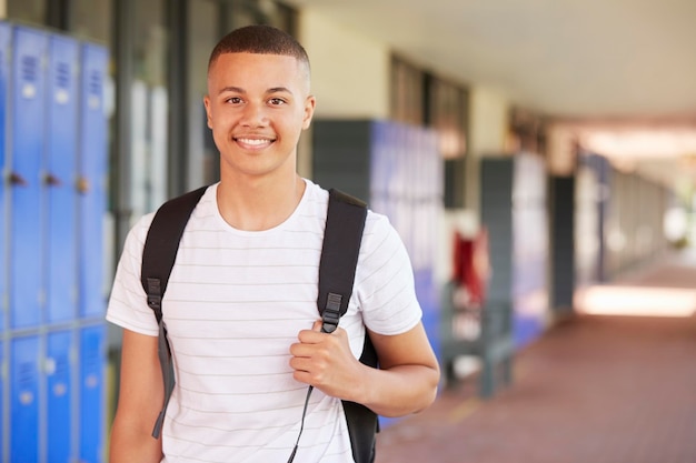 Happy mixed race woman smiling in high school corridor