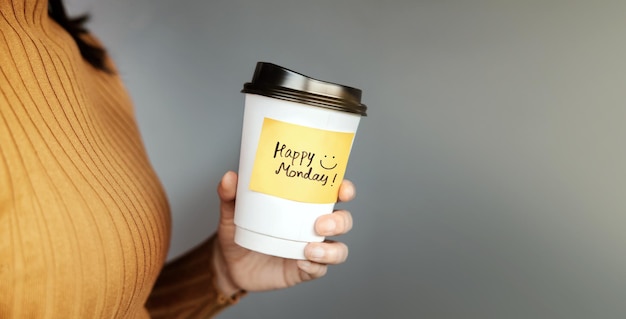 Happy Monday Happiness Mind Enjoying Life Concept Business Woman holding a Coffee Cup with Positive Note from a Barista Start the Day Side View