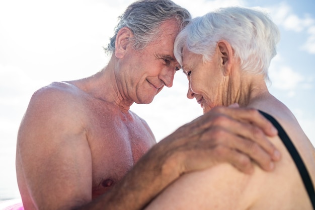 Happy senior couple embrassant face à face sur la plage