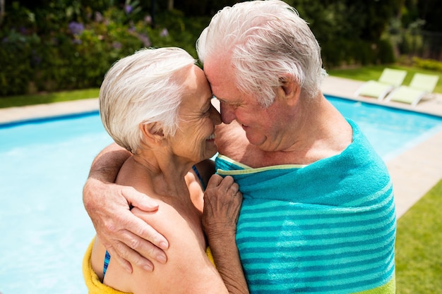 Happy senior couple s'embrassant au bord de la piscine