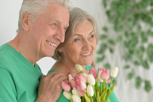 Happy senior man donne des fleurs à une femme