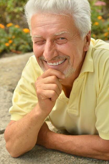 Happy senior man sur une promenade dans le parc en été