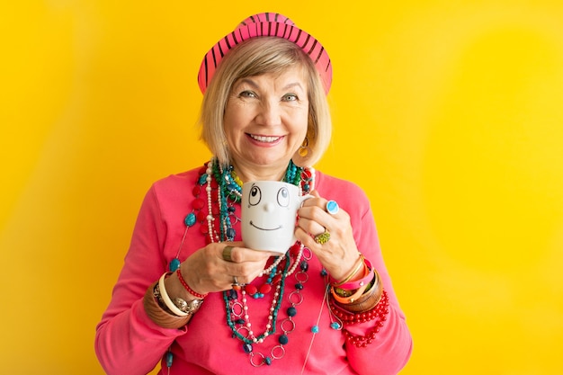 Happy Senior woman funny face buvant une tasse de café ou de thé dans des vêtements élégants personnes âgées