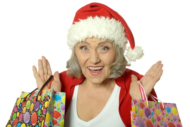 Happy senior woman with shopping bags sur fond blanc