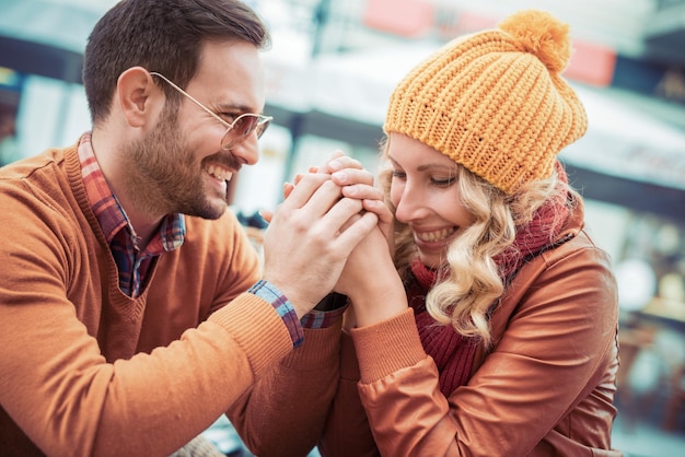 Happy smiling attractive young couple date sitting in street cafe