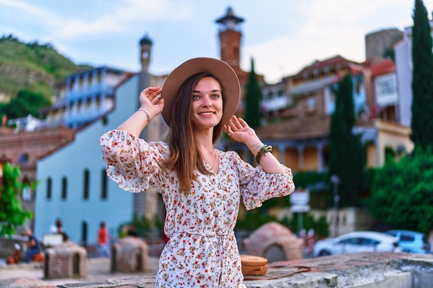 Happy smiling traveler girl sur fond de bains de soufre dans le quartier Abanotubani de la vieille ville de Tbilissi, Géorgie