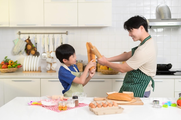 Happy smiling Young Asian père et fils cuisine dans la cuisine à la maison