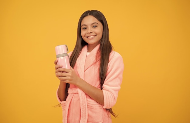 Happy teen girl in home peignoir éponge avec bouteille thermos matin