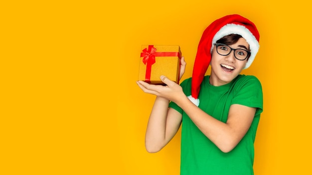 Happy Teen in Santa Hat avec des cadeaux de Noël