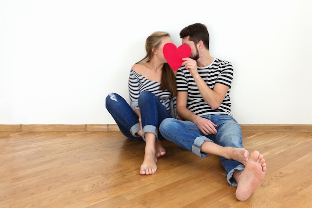 Happy valentines couple assis sur un plancher en bois espace de copie de fond blanc