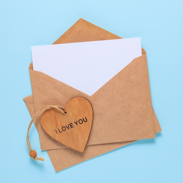 Happy Valentines Day Craft enveloppes papier vierge carte blanche et coeur en bois sur fond bleu