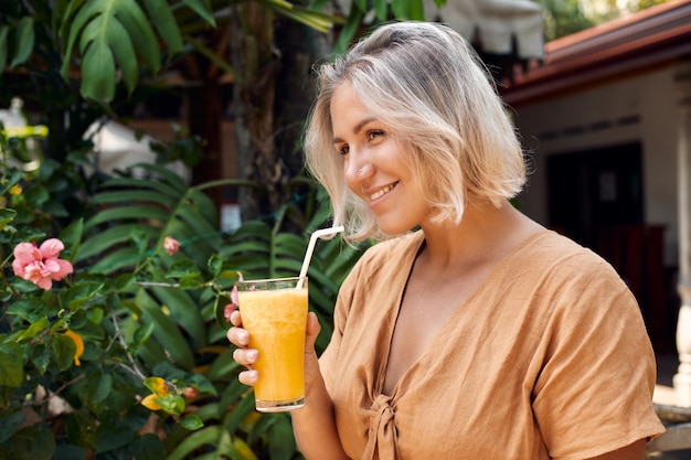 Happy Woman Drink Cocktail de smoothie jaune exotique