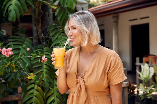 Happy Woman Drink Cocktail de smoothie jaune exotique