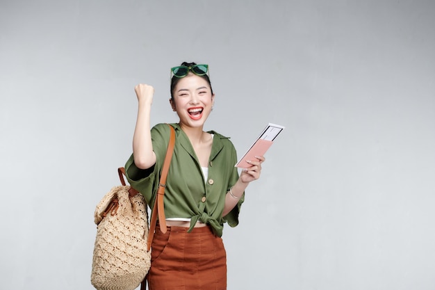 Happy woman girl avec valise et passeport sur fond gris