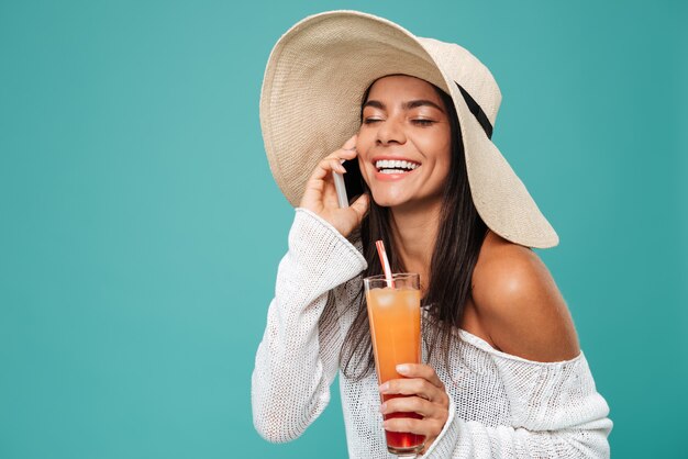 Happy Woman in beachwear parler au téléphone avec cocktail
