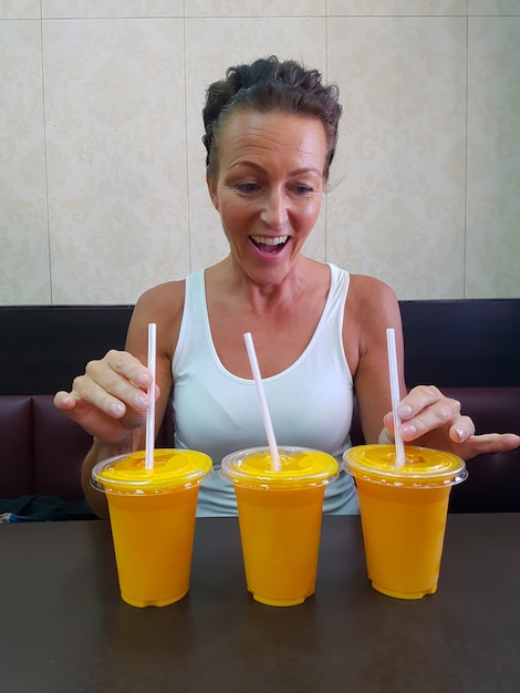 Photo happy woman looking at mango lassi drink à l'intérieur du restaurant indien vertical shot