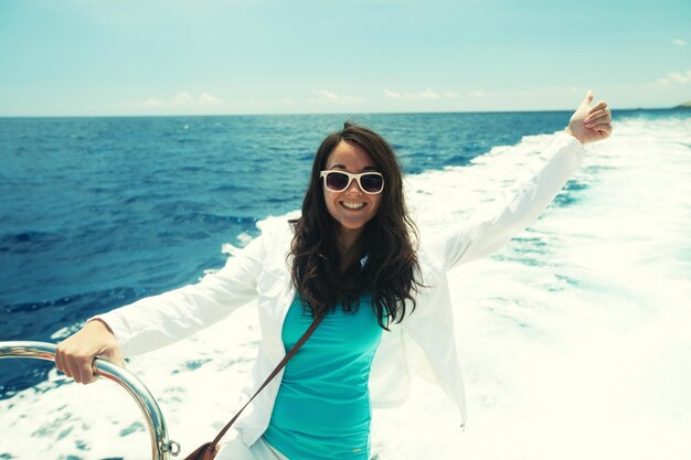 Happy Woman profitant d'une journée d'été ensoleillée sur une position de bateau inspire la liberté