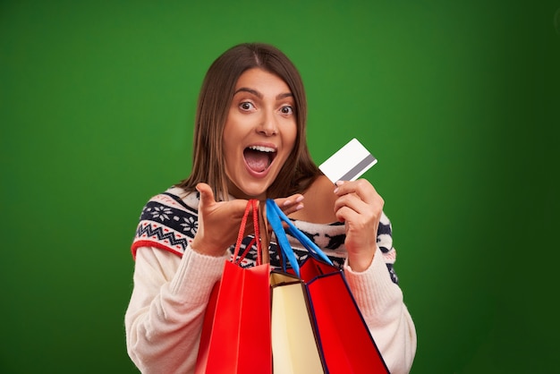 Happy woman shopping pour les cadeaux de Noël sur fond vert