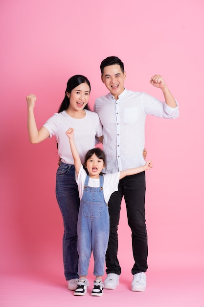 Happy young asian family image isolée sur fond rose