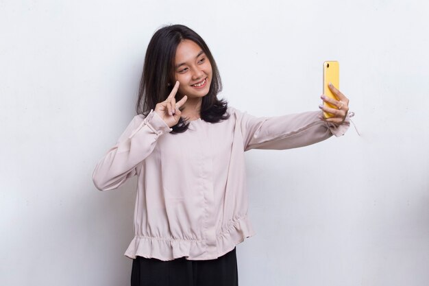 Happy young asian woman using mobile phone isolé sur fond blanc