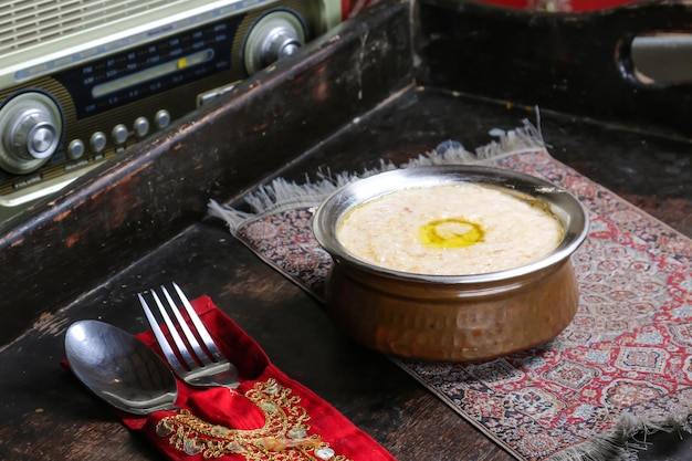 Hareesa ou harees plat arabe servi dans un plat isolé sur une vue de dessus de tapis rouge sur la table de la nourriture arabe