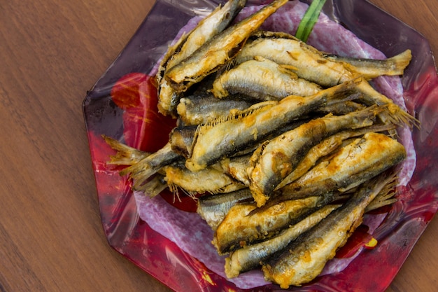 Hareng de la Baltique frit sur une assiette sur fond de bois