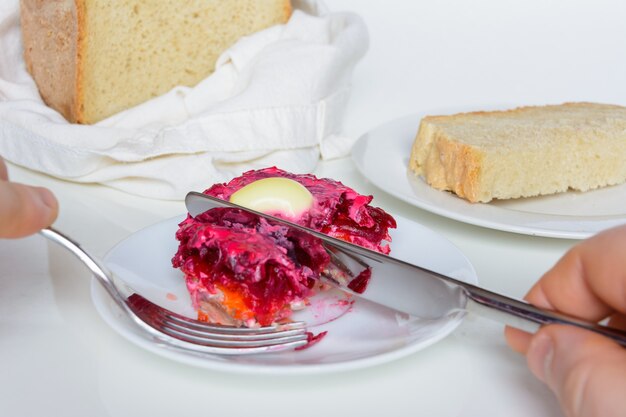 Hareng habillé ou hareng sous un manteau de fourrure. Cuisine traditionnelle russe. Salade étagée composée de dés de hareng mariné recouvert de couches de légumes râpés bouillis et de mayonnaise.